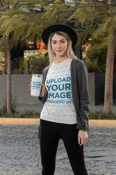 T-Shirt Mockup of a Stylish Woman Holding a Travel Mug