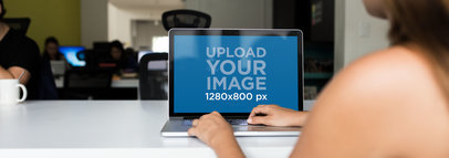 Mockup of a Woman Using her MacBook Pro at a Cool Office