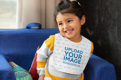 Mockup of a Little Girl Wearing a Baby Bib at Home 