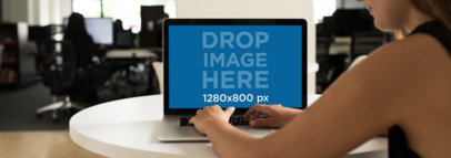 MacBook Pro Mockup Featuring a Young Woman Working in a Modern Office