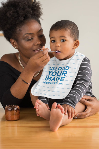 Bib Mockup Featuring a Mother Feeding Her Baby Boy 
