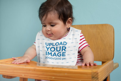 Bib Mockup Featuring a Baby in a High Chair 