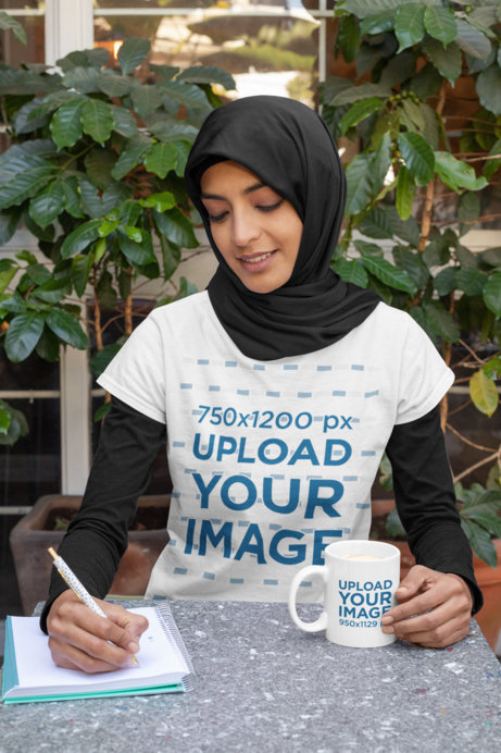 T-Shirt Mockup of a Young Woman Drinking from a Coffee Mug While Working 