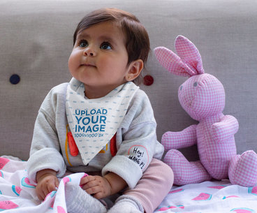 Bib Mockup Featuring a Baby Girl Sitting Next to a Stuffed Bunny 32473