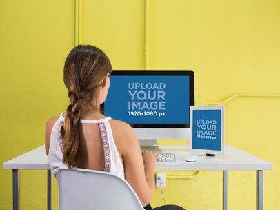 iMac and iPad Mockup in a Yellow Office Used by a Woman