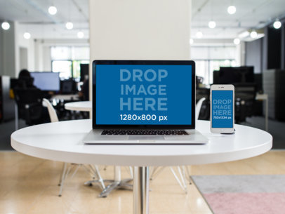 Mockup of a MacBook Pro + iPhone on a White Round Table in an Office Space