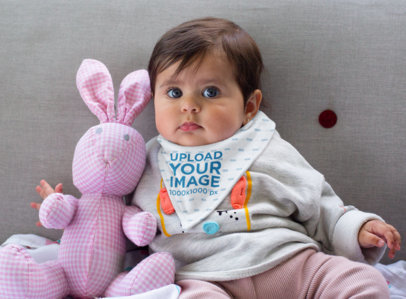 Bib Mockup Featuring a Girl Posing Next to a Stuffed Animal