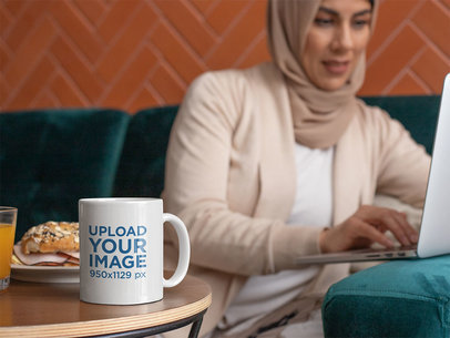 11 oz Coffee Mug Mockup Featuring a Woman Working on the Computer 