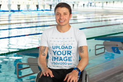 T-Shirt Mockup of a Tattooed Man Using a Wheelchair Next to a Pool