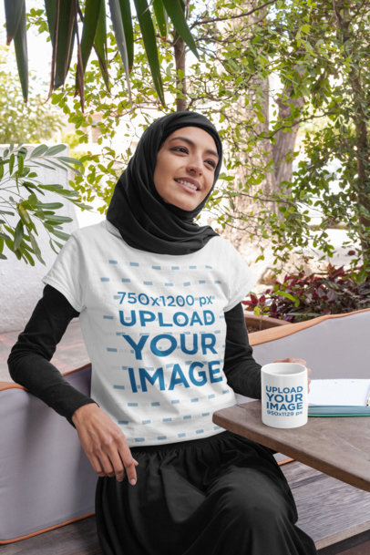 T-Shirt Mockup of a Woman Wearing a Hijab with an 11 oz Mug in Her Hand