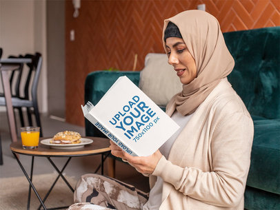 Book Mockup of a Woman with a Hijab Reading at Home