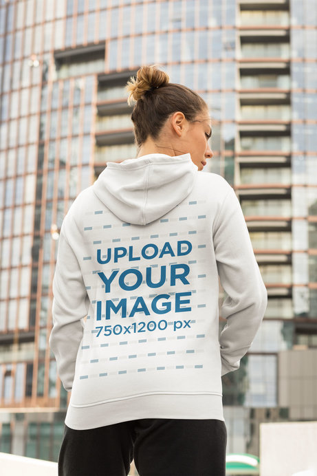 Hoodie Mockup of a Woman in an Athleisure Look on a Street with Skyscrapers 