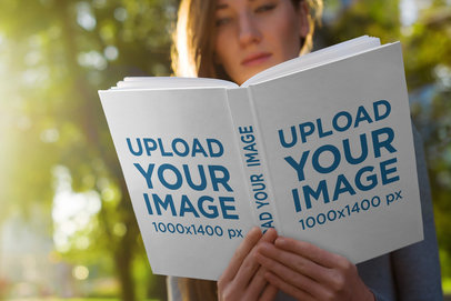 Hardcover Book Mockup Featuring a Young Woman Reading at the Park 