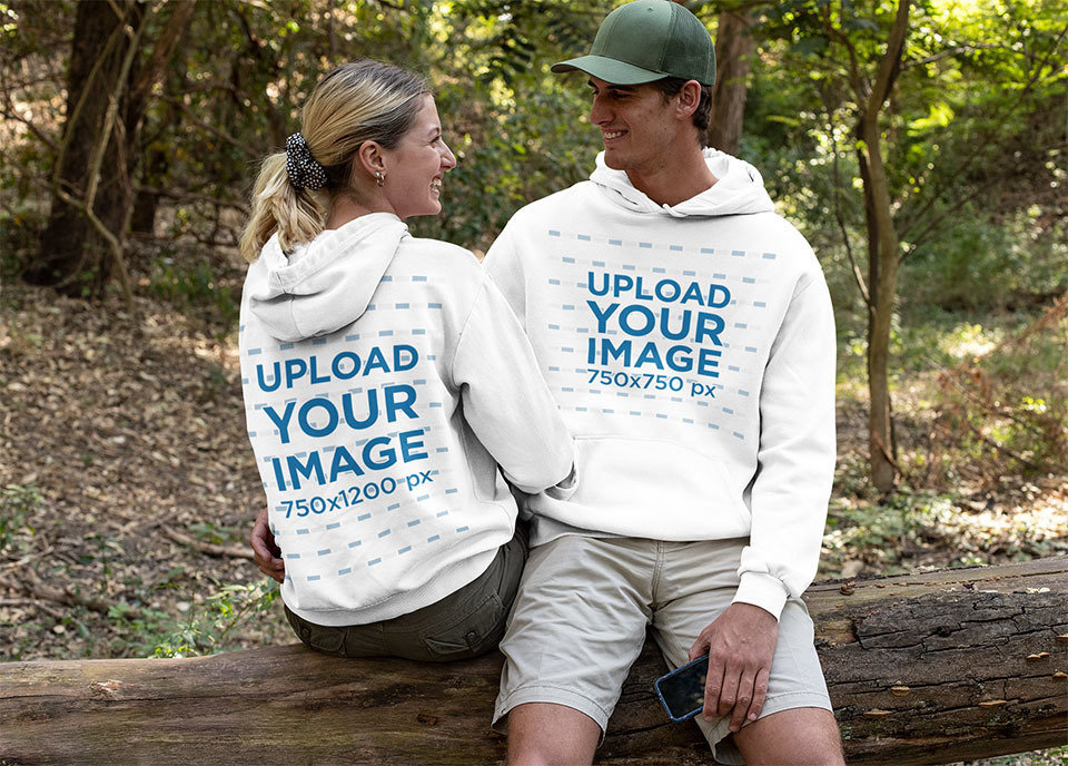 Hoodie Mockup of a Couple Sitting Together in the Woods