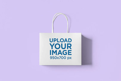 Minimal Mockup Featuring a Gift Bag Lying Over a Plain Color Surface 