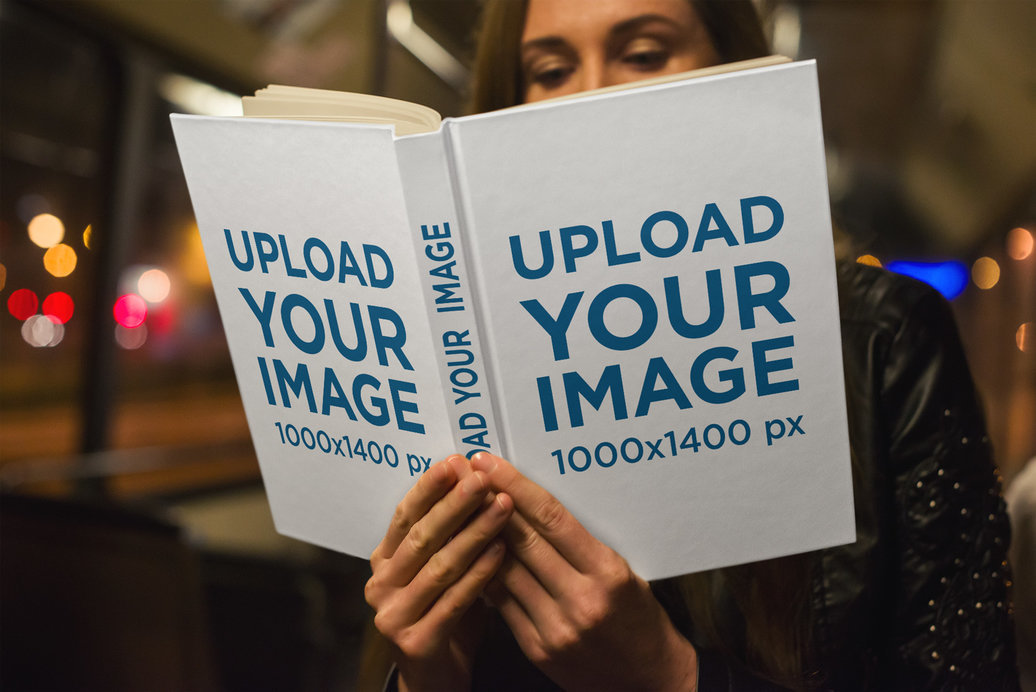 Mockup of a Woman Reading a Hardcover Book at Night