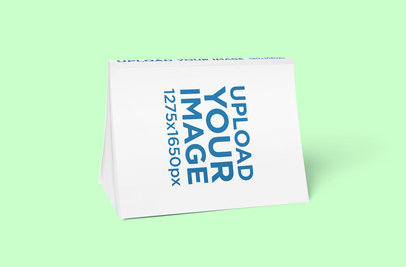 Mockup of a Magazine Balancing on Its Pages 3379-el1