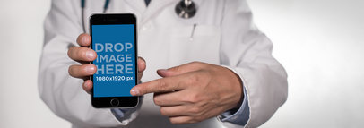 Black iPhone Plus Mockup Held in Frontal View by a Male Doctor