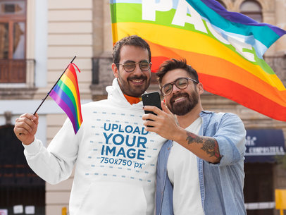 Pullover Hoodie Mockup Featuring a Couple Taking a Selfie in Front of an LGBT Pride Flag 