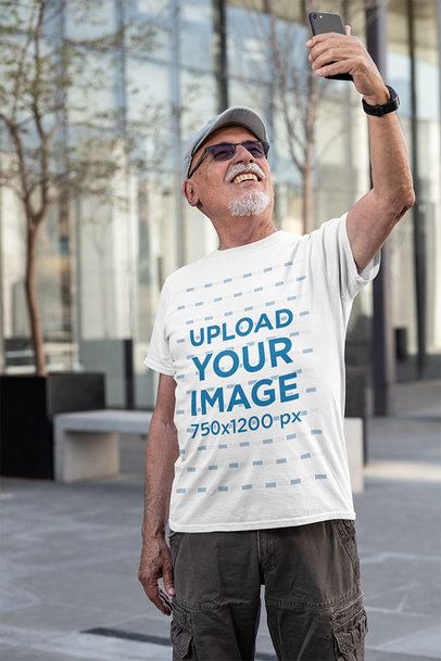 T-Shirt Mockup of a Senior Man Taking a Selfie
