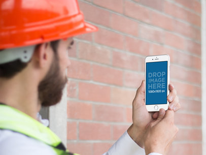 Mockup of a Construction Worker Using an iPhone 6 in Portrait Position
