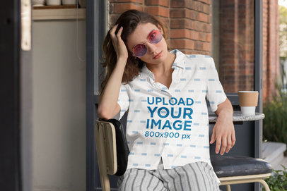Button up Shirt Mockup Featuring a Woman Sitting on a Chair Outside a Cafe 33135