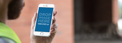 White iPhone 6 Plus Mockup of a Construction Worker Checking his Phone