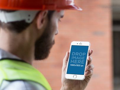 Mockup of a Construction Man Using His iPhone in Portrait Mode