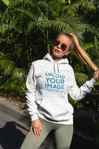 Hoodie Mockup of a Woman Posing in a Tropical Scenario