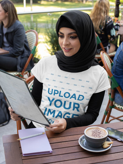 T-Shirt Mockup Featuring a Woman Wearing a Hijab and Ordering at a Restaurant 