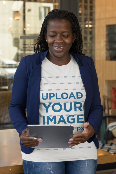 T-Shirt Mockup Featuring a Middle-Aged Woman Looking at Her Tablet
