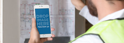 iPhone 6 Mockup of an Architect Reviewing a Blueprint