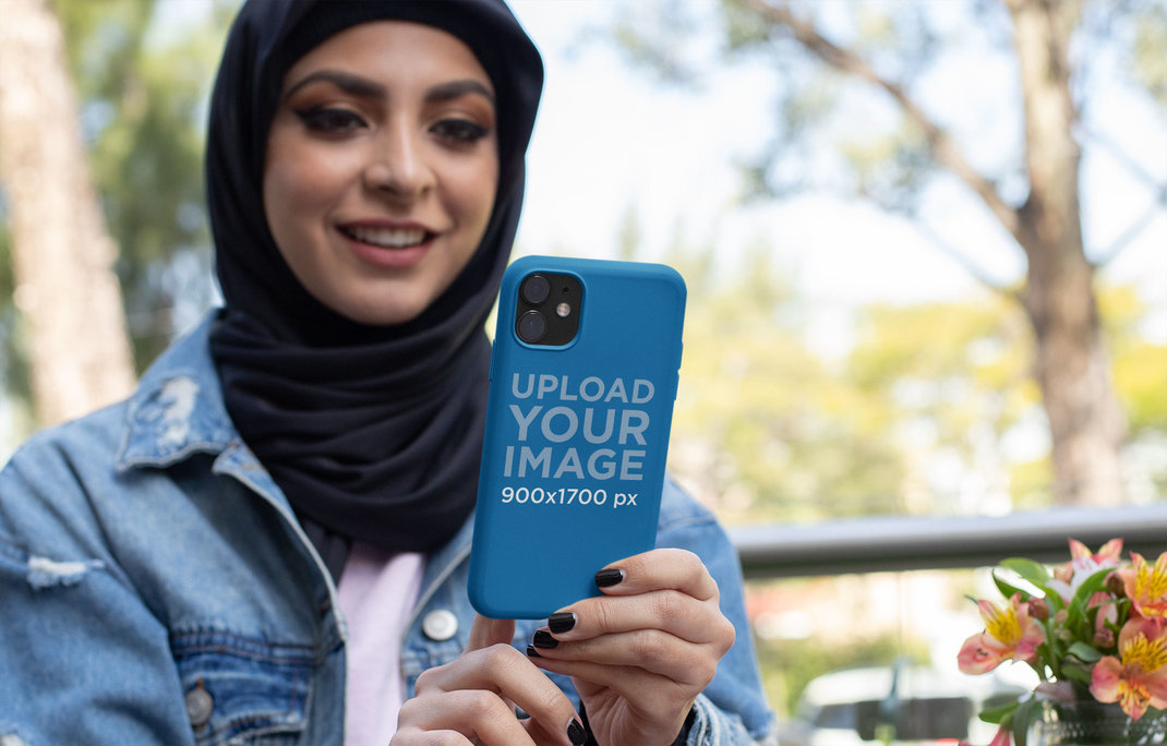 Mockup of a Woman Holding a Phone Case at a Restaurant 