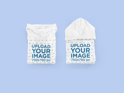 Mockup Featuring Two Folded Hoodies Placed Over a Colored Surface