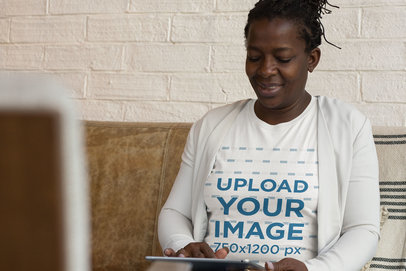 Mockup Featuring a Middle-Aged Woman Wearing a T-Shirt While Using a Tablet 
