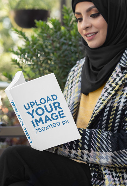 Mockup of a Woman in a Hijab Holding a Paperback Book
