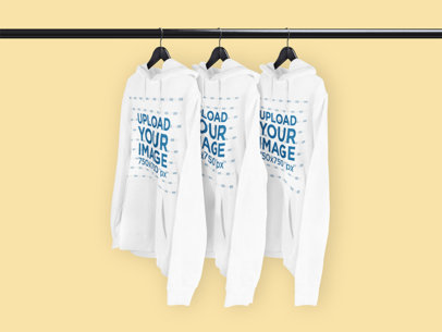 Mockup of Three Pullover Hoodies Hanging from a Rack 3587-el1