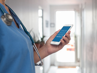 Mockup of a Female Doctor Using an iPhone in Portrait Mode in a Hospital 12411