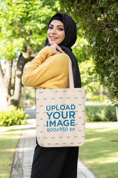 Mockup of a Smiling Woman in a Hijab Holding a Tote Bag