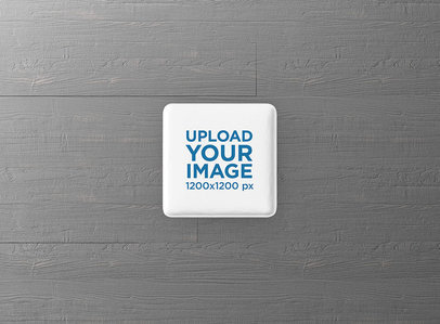Square Pin Button Mockup Featuring a Grey Wooden Surface