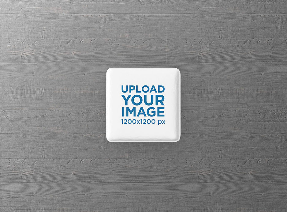 Placeit - Square Pin Button Mockup Featuring a Grey Wooden Surface