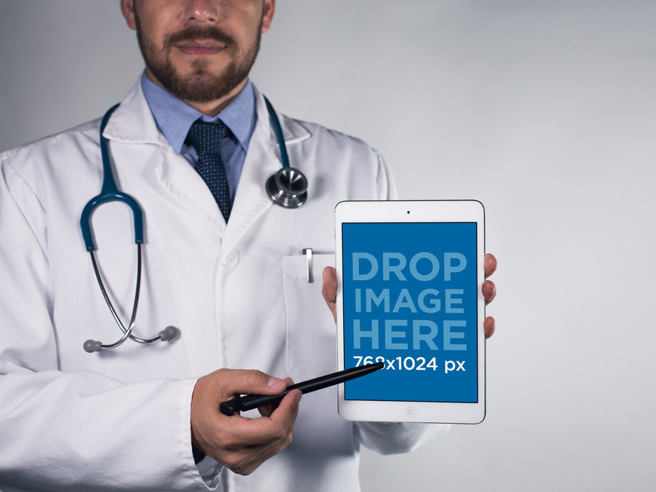 Mockup of a Bearded Doctor Pointing at His iPad in Portrait Mode