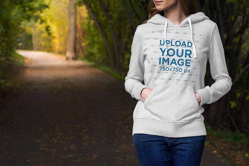 Hoodie Mockup of a Woman Walking by a Park Lane