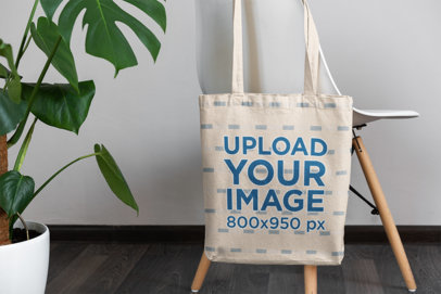 Mockup Featuring a Tote Bag Hanging From a Modern Chair 