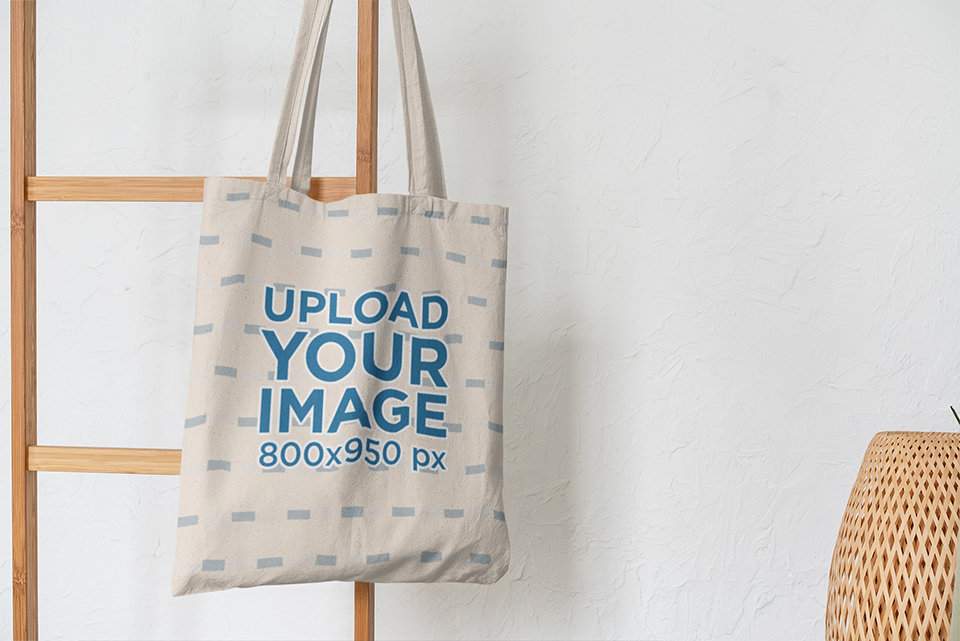 Mockup of a Tote Bag Hanging from a Wooden Stair