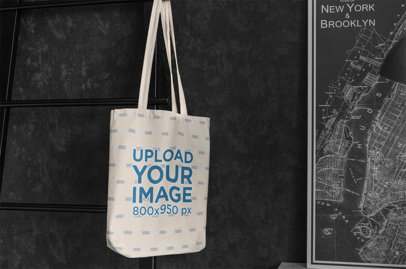 Mockup of a Sublimated Tote Bag Hanging by a Framed Map 3142-el1