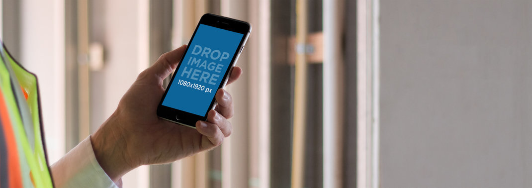 Mockup of an iPhone Plus Held by an Onsite Construction Worker
