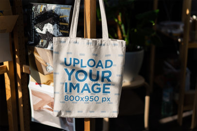 Mockup of a Canvas Bag Hanging From a Wooden Rack 