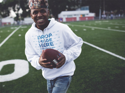 Smiling Young Black Man Playing Football Wearing a Hoodie Mockup b12450