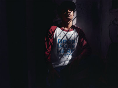 Raglan Tee Mockup of a Young Man Sitting in a Dark Room